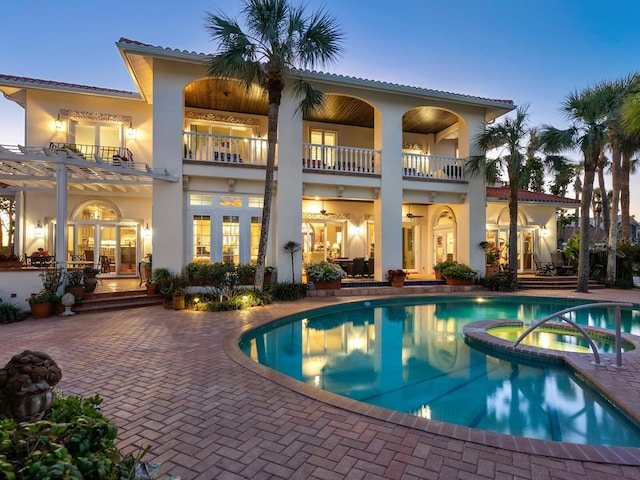 exterior space with a patio area, french doors, and a pool with connected hot tub