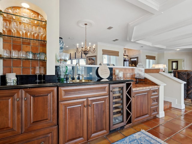 bar with tasteful backsplash, visible vents, indoor wet bar, crown molding, and beverage cooler