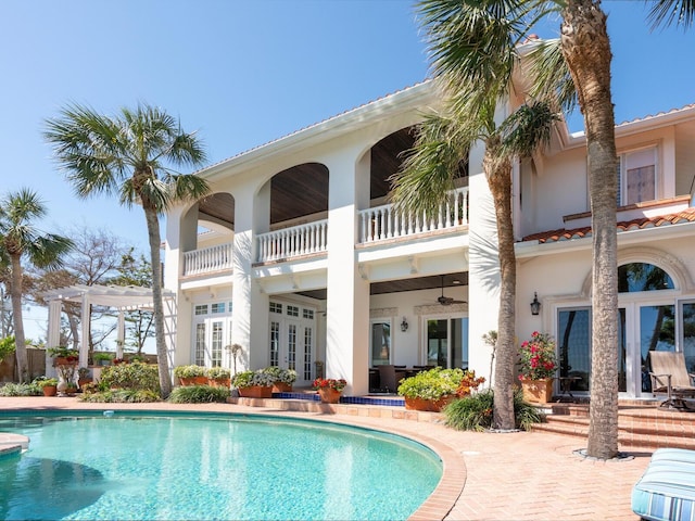 pool with a pergola, a patio area, and french doors