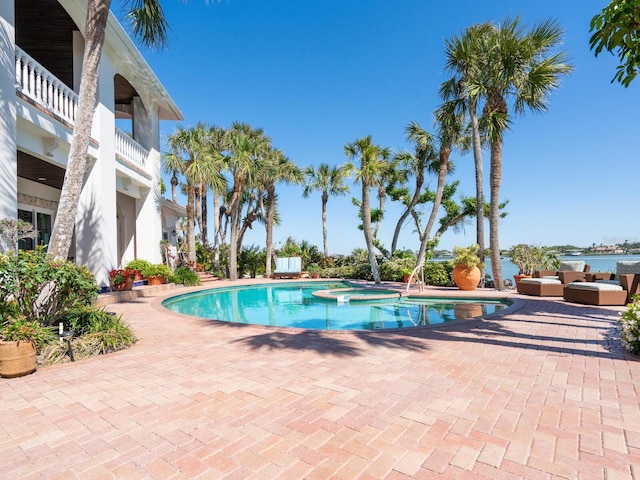 view of pool featuring a patio and a pool with connected hot tub