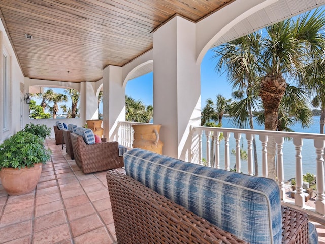 view of patio / terrace with a water view, a balcony, and an outdoor hangout area