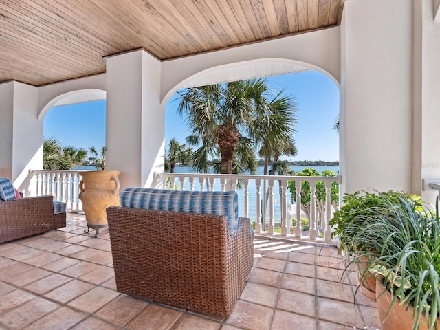 view of patio featuring a water view and a balcony