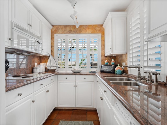 kitchen with backsplash, white cabinetry, a sink, and white appliances