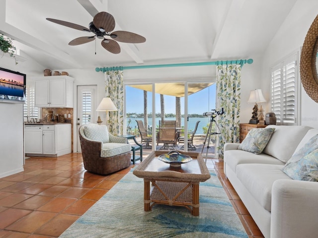 living area with tile patterned floors, vaulted ceiling with beams, and ceiling fan