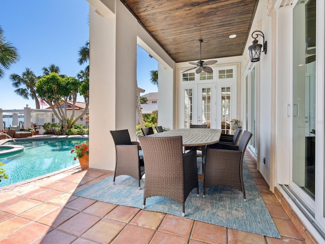 view of patio with french doors, ceiling fan, a pool with connected hot tub, and outdoor dining area