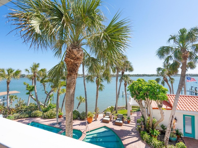 view of pool with a water view, a pool with connected hot tub, a patio, and stairs
