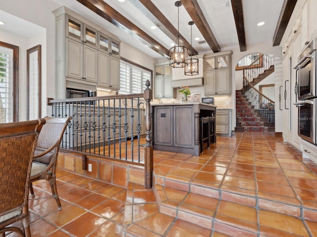 kitchen featuring tasteful backsplash, beamed ceiling, glass insert cabinets, and light tile patterned floors