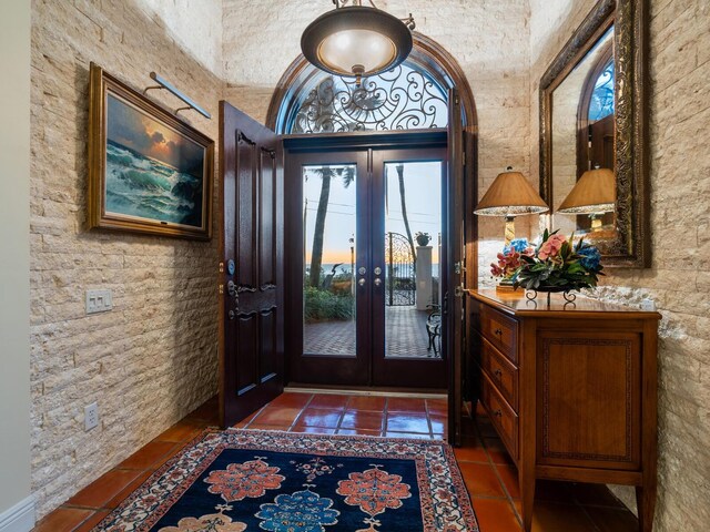 entryway featuring dark tile patterned floors and french doors