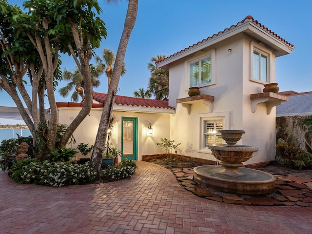 view of front of home featuring a tiled roof and stucco siding