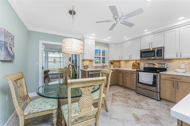 kitchen with decorative backsplash, crown molding, stainless steel appliances, and light countertops