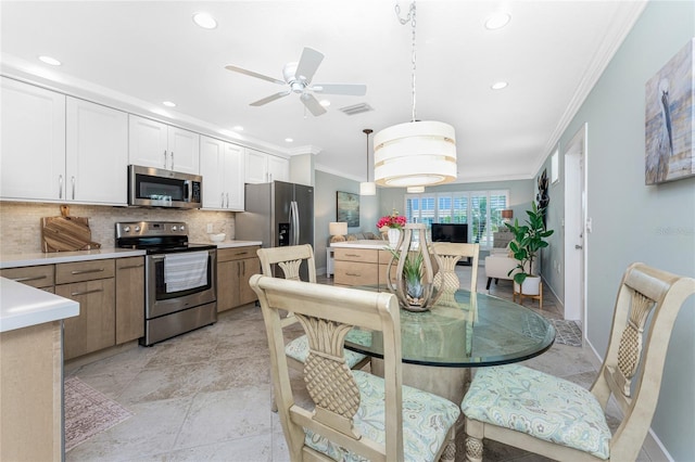 kitchen featuring backsplash, appliances with stainless steel finishes, ornamental molding, and light countertops