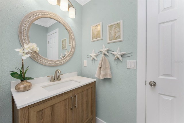 bathroom with vanity, a textured wall, and ornamental molding