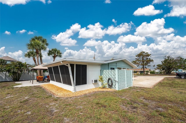 rear view of property with a patio, fence, a lawn, and a sunroom