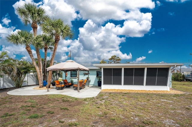 back of house with a lawn, fence, a gazebo, a sunroom, and a patio area