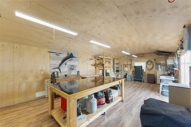 kitchen featuring wood finished floors, wood walls, and vaulted ceiling