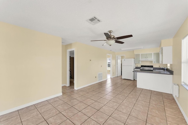 kitchen with visible vents, electric stove, dark countertops, radiator heating unit, and freestanding refrigerator