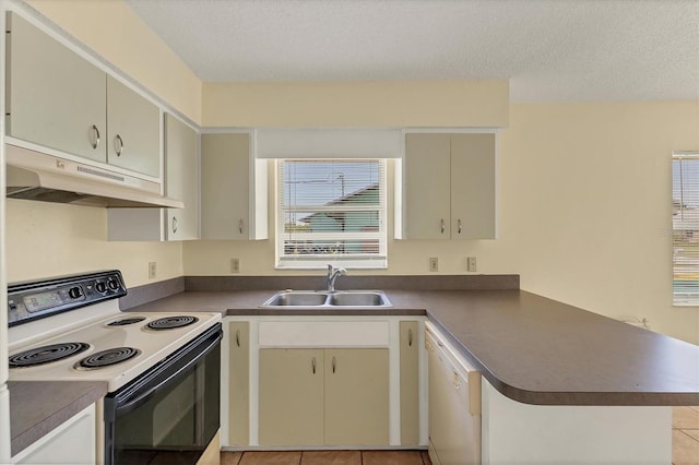 kitchen with a peninsula, a sink, electric stove, under cabinet range hood, and dark countertops