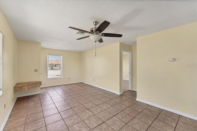 spare room featuring light tile patterned flooring, baseboards, visible vents, and ceiling fan