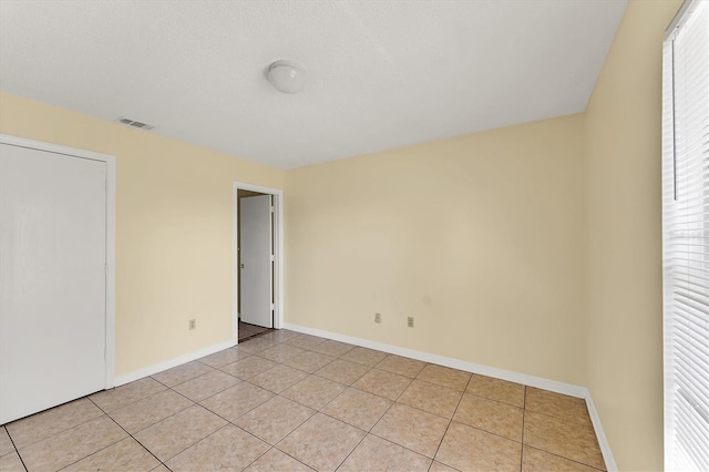 unfurnished room featuring light tile patterned floors, baseboards, and visible vents