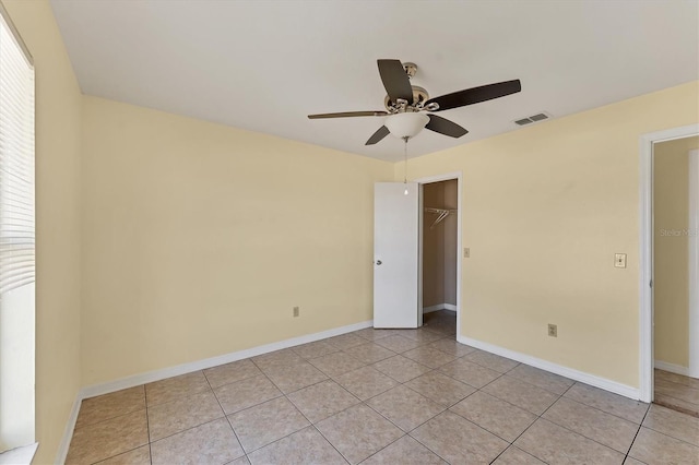 unfurnished room with visible vents, baseboards, light tile patterned flooring, and a ceiling fan