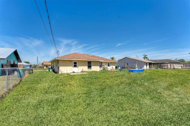 back of house with a yard and fence