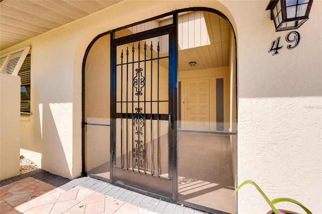 view of exterior entry featuring stucco siding