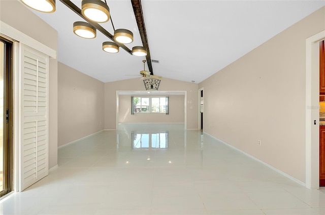 unfurnished room with light tile patterned flooring, baseboards, and vaulted ceiling