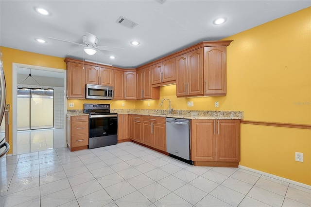 kitchen with light stone counters, visible vents, stainless steel appliances, and ceiling fan