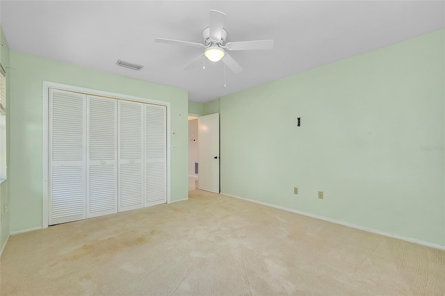 unfurnished bedroom featuring visible vents, baseboards, carpet floors, a closet, and a ceiling fan