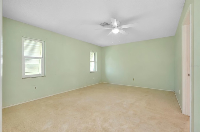 unfurnished room with baseboards, light carpet, and a ceiling fan