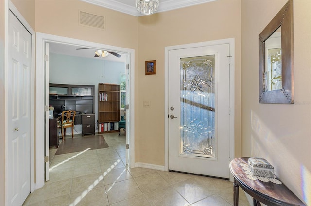 doorway with tile patterned floors, visible vents, ornamental molding, a ceiling fan, and baseboards