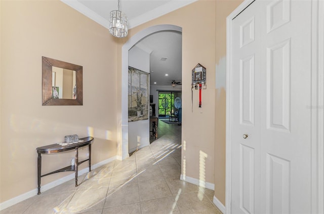 corridor featuring tile patterned flooring, baseboards, and arched walkways