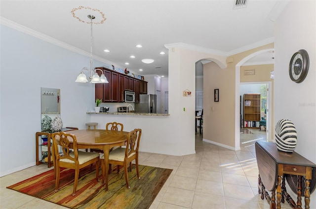 dining space featuring light tile patterned floors, baseboards, arched walkways, and ornamental molding