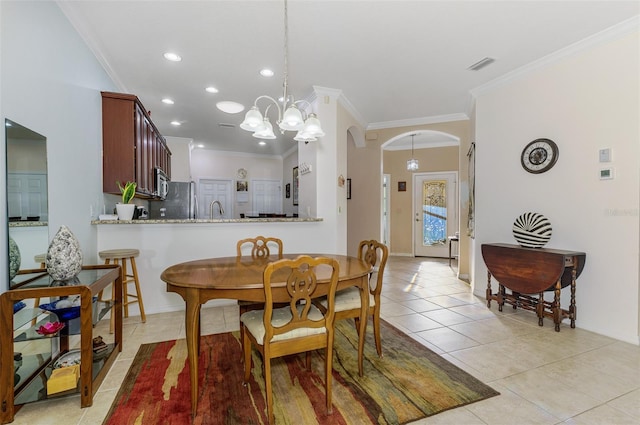 dining area with visible vents, crown molding, a chandelier, light tile patterned flooring, and arched walkways