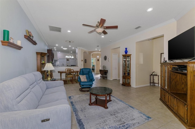 living room featuring visible vents, ornamental molding, light tile patterned floors, arched walkways, and a ceiling fan