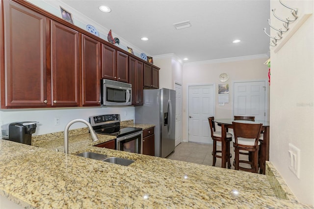 kitchen with light tile patterned floors, light stone countertops, ornamental molding, dark brown cabinets, and appliances with stainless steel finishes