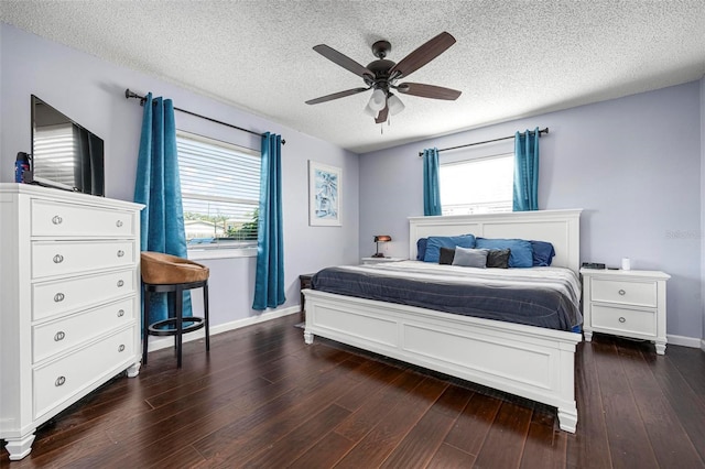 bedroom with a ceiling fan, dark wood-style floors, baseboards, and a textured ceiling