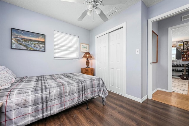 bedroom with visible vents, baseboards, wood finished floors, a closet, and a textured ceiling