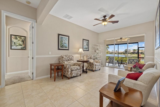 living area with light tile patterned floors, visible vents, baseboards, and a ceiling fan