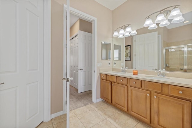 full bath featuring a sink, double vanity, a stall shower, and tile patterned floors