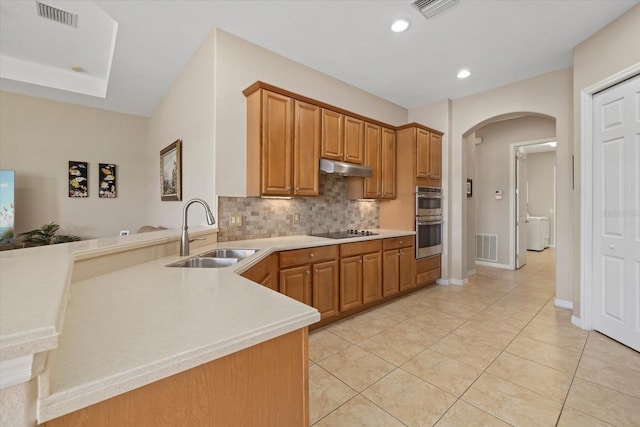 kitchen featuring visible vents, a sink, under cabinet range hood, double oven, and black electric cooktop