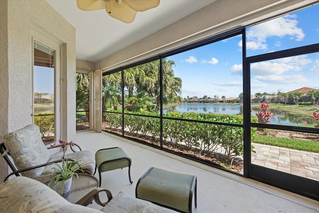 sunroom / solarium with a water view and ceiling fan