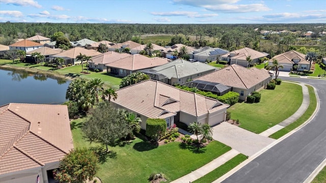 birds eye view of property with a forest view, a residential view, and a water view