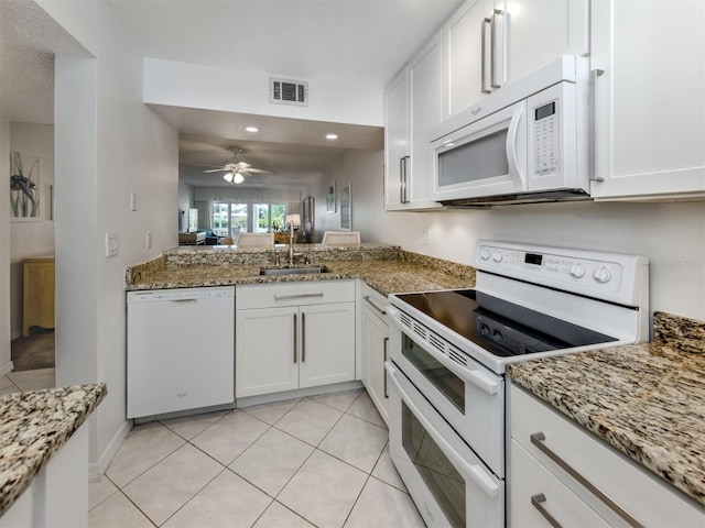 kitchen with visible vents, a sink, white appliances, white cabinets, and light stone countertops