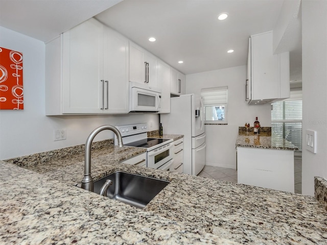 kitchen with light stone counters, recessed lighting, white cabinets, white appliances, and a sink