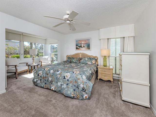 bedroom with ceiling fan, carpet flooring, and a textured ceiling