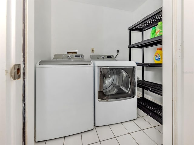 laundry room with light tile patterned flooring, laundry area, and washing machine and clothes dryer