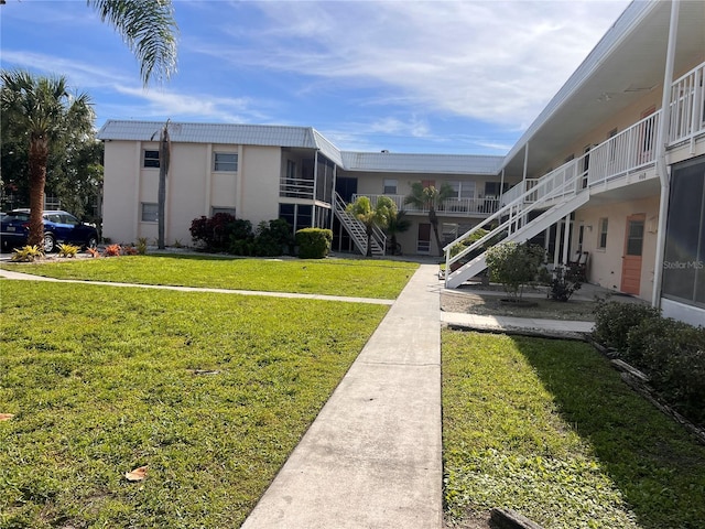 view of home's community featuring stairway and a lawn