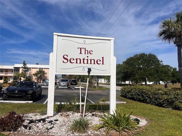 community / neighborhood sign with uncovered parking