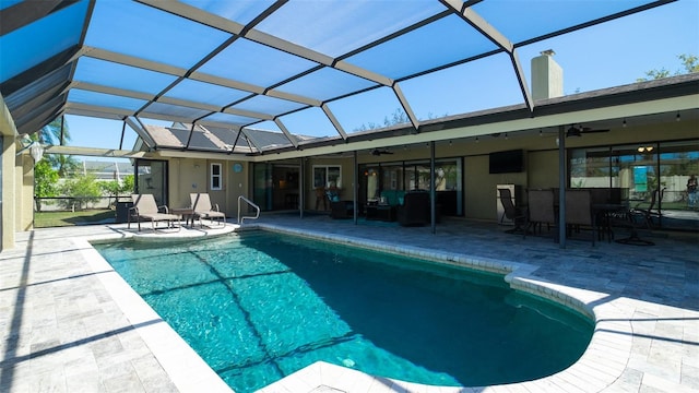 pool featuring a patio area, glass enclosure, and a ceiling fan